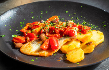pan-fried fish fillet with tomatoes, potatoes, olives and capers