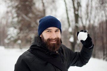 Fototapeta na wymiar bearded guy playing snowballs