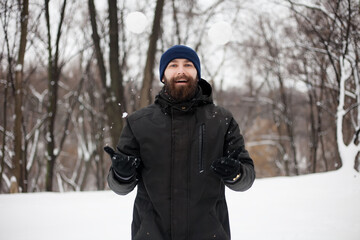 Fototapeta na wymiar bearded guy playing snowballs