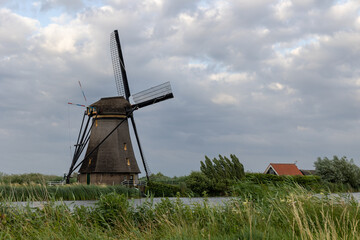 Beautiful wooden windmills at sunset in the Dutch village of Kinderdijk. Windmills run on the wind. The beautiful Dutch canals are filled with water. Beautiful sunset.