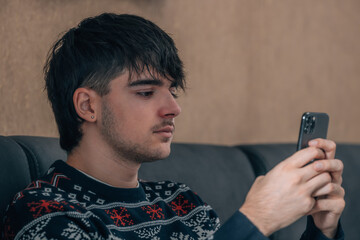 young man at home looking at mobile phone