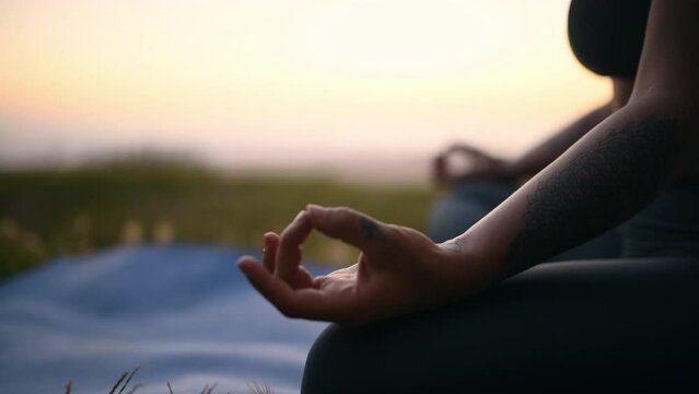 Woman, meditate and hands in nature at sunrise with beach, zen and calm outdoor. Morning, yoga and wellness on grass and relax with a female person with spiritual peace and sunset by sea and ocean
