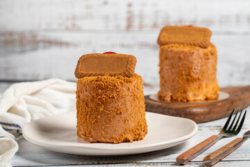 Biscuit cake. Delicious cream cake on a white background. Cake with fruit inside and biscuits on the outside