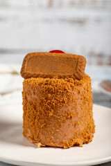 Biscuit cake. Delicious cream cake on a white background. Cake with fruit inside and biscuits on the outside