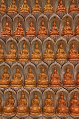 wall of miniature buddha statues vertical 