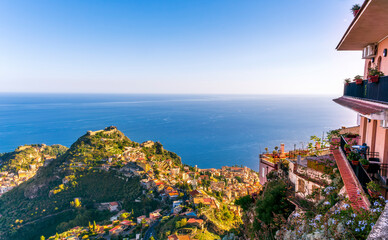 panoramic balcony view from mountain hotel to picturesque town and blue water of sea gulf with nice clouds and sunrise or sunset sky