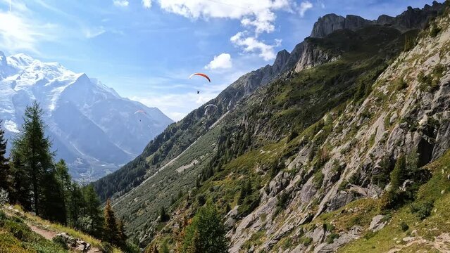 Mountains. Climbing to the top of Le Brevent, French Alps, Chamonix. Beautiful mountain landscape, blue sky, forest, rocks, paragliders. Tourist walk