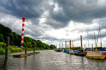 Red and white lighthouse Muehlenberg near Hamburg. Historic lighthouse on the Elbe at the...