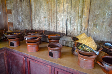 a collection of food containers made of clay containing traditional Javanese food at a buffet...