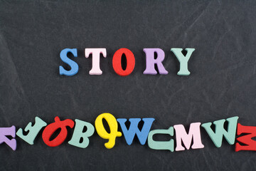 STORY word on black board background composed from colorful abc alphabet block wooden letters, copy space for ad text. Learning english concept.