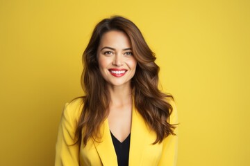 Portrait of happy smiling young woman in yellow jacket, over yellow background