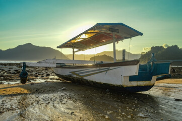 a wooden fishing boat that can also be rented for beach tourism at dusk