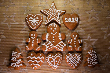Christmas homemade gingerbread cookies on the table on a golden background in the 2024 new year