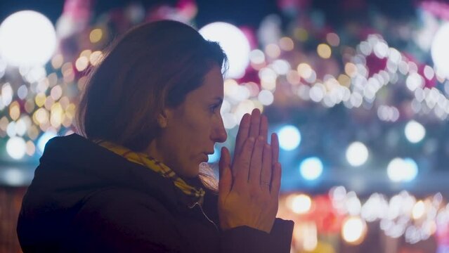 Woman in the evening on the Champs-Elysees in Paris. Christmas mood among tourists buying a warm drink in winter. Christmas lights, glitter decorations