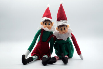 Closeup of two elves on the shelf sitting on white background - 690580504
