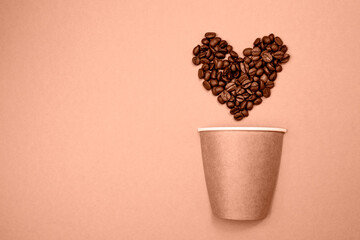 Natural reusable paper cup and heart shaped coffee beans. Zero Waste Lifestyle. Trendy color of...