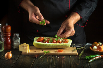 The chef is preparing the American national dish of zucchini. Adding fragrant parsley to a boat dish by the cook hand