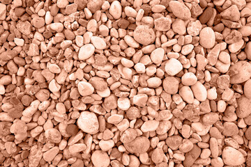 Natural background. Stones close-up, top view. Trendy color of year 2024 - Peach Fuzz.