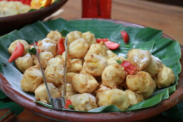 Tahu Goreng (Indonesian deep fry tofu) decorated with strawberry slices on banana leaf platting 