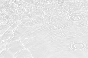 White water with ripples on the surface. Defocus blurred transparent white colored clear calm water surface texture with splashes and bubbles. Water waves with shining pattern texture background.