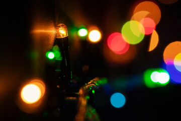 Abstract Christmas lights on black background. Glowing light bulb garland,