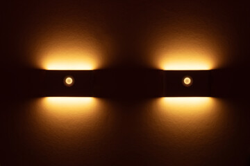 Two small solar night led light with motion sensor on wall. - obrazy, fototapety, plakaty
