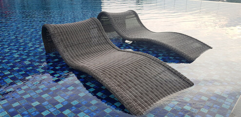 relax deck chair by the blue pool at swimming pool in luxury spa resort or villa Tourism industry