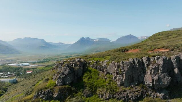 Summer landscape of Nordic nature, coastal hinterland in Iceland with picturesque valley and magnificent mountains in the background, aerial shot.