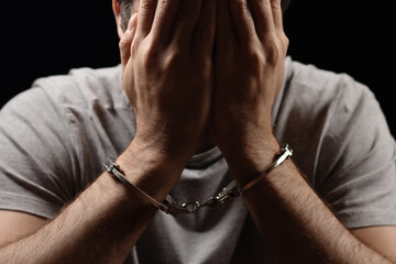 Man, criminal and handcuffs for interrogation, crime or money laundering in arrest on table in room.