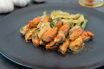 Mussels stir-fried with vegetables and herbs or mussels with basil on a plate