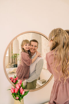 happy father with daughter reflection in the mirror