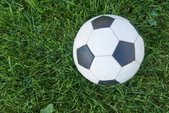 Football ball on green grass. top view with copy space. Sports and recreation concept