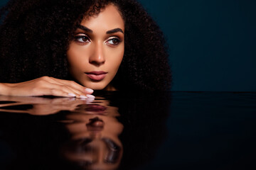 Fototapeta premium Portrait of stunning lady relaxing enjoying hydration procedure in dark aesthetic bathroom with clear water