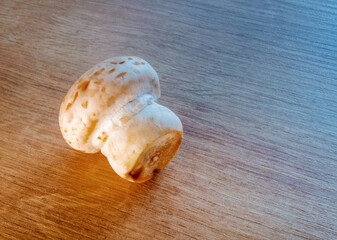 The raw mushroom on wooden table, illuminated with light in vibrant colors.