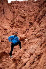 Aventurero escalando uno de los cerros colorados en la localidad de Purmamarca, en Jujuy