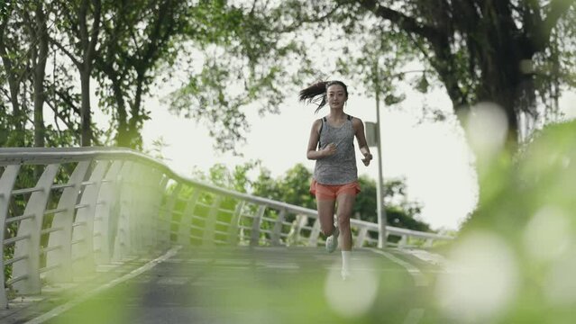 young asian woman female jogger running exercising outdoors in park