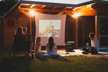 Fotobehang Friends having fun in home backyard open air cinema watching a movie © Impact Photography