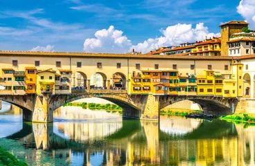 Photo sur Plexiglas Ponte Vecchio Ponte Vecchio stone bridge with colourful buildings houses over Arno River blue reflecting water