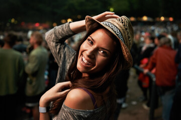 Happy woman, portrait and night at music festival party, event or outdoor DJ concert. Face of female person smile with hat in evening crowd or audience at carnival, performance or summer fest outside