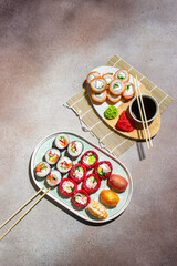 a set of bright colorful rolls and sushi. traditional Japanese food. Oriental cuisine. Rolls with red rice and meat. top view