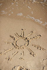 Shape of sun with incoming sea wave on sand at beach. Summer and vacation time
