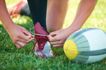 Rugby, ball and sports with shoes of person on field for training, practice and challenge. Health, start and games with closeup of athlete tying laces on outdoor pitch for stadium and fitness