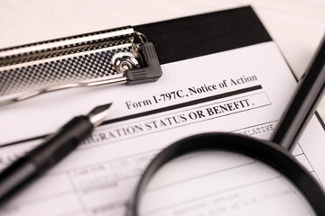 I-797c Notice of action blank form on A4 tablet lies on office table with pen and magnifying glass close up