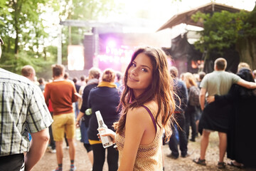 Woman, portrait and drink at outdoor music festival with crowd for party or event in nature. Face of female person smile and enjoying sound or audio at carnival, concert or performance outside - obrazy, fototapety, plakaty
