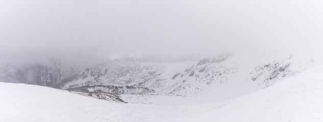 The white snow peaks of Pirin partly covered by fog.  Snowy weather conditions for winter sports...