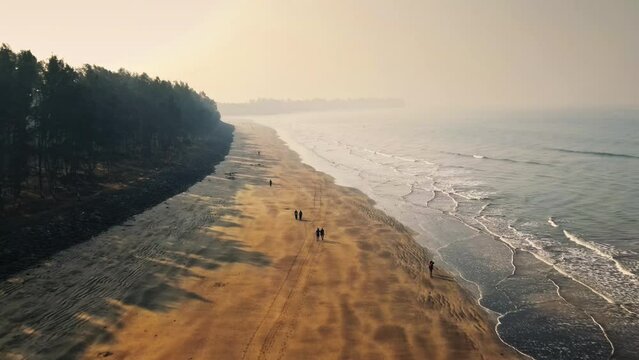 Alibuag Beach, Maharashtra, India 20-11-2023: A bird's eye view of Alibaug Beach shows a beautiful coastline with people strolling by the foamy waves. Beautiful Indian Beaches.