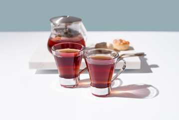 Té rojo con pasteles y dulces sobre mármol	
