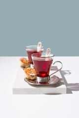 Dos tazas de té rojo con dulces sobre mármol	