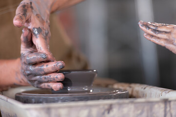 Portrait of a senior Asian couple doing activities together in the pottery workshop.