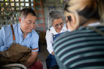 Portrait of a senior Asian couple doing activities together in the pottery workshop.